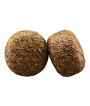 Two round kibble pieces of Josera Help Renal gluten-free kidney support dog food for adult dogs.