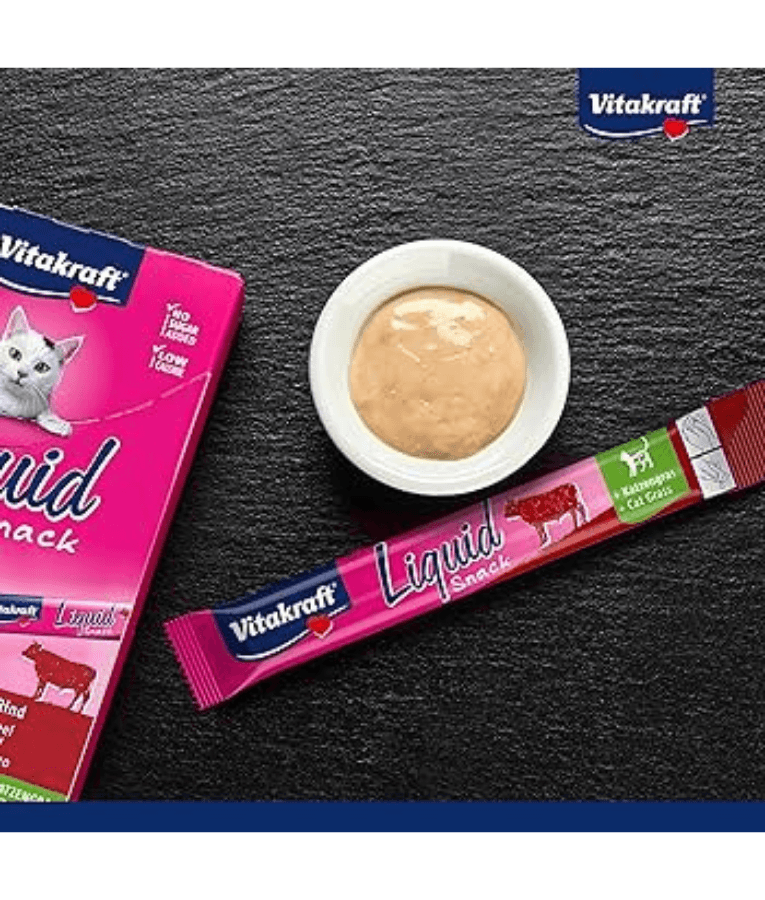 Vitakraft Liquid Snack Beef in a bowl with sachet on a dark surface, ideal for cat digestive support.