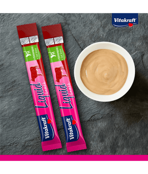 Vitakraft Liquid Snack Beef sachets and creamy treat in bowl on slate background, digestive support for cats.