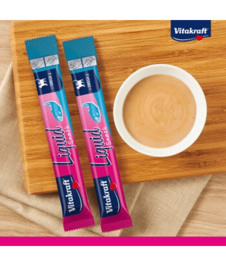 Vitakraft Liquid Snack Salmon sachets with creamy snack in bowl for cat skin and coat support.
