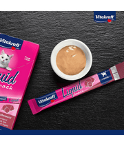 Vitakraft Liquid Snack Liver Sausage in sachet with creamy treat in bowl, low-calorie cat treat for all life stages.