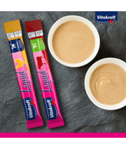 Vitakraft liquid cat treats multipack with chicken and beef flavors in bowls on a slate background.