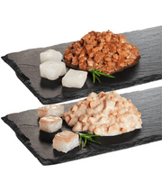 High quality cat food showing moist pieces of pollock and cod served on a dark slate platter.
