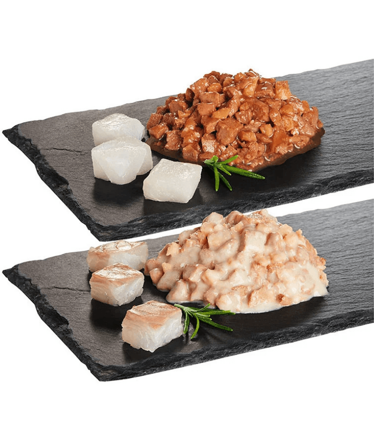 High quality cat food showing moist pieces of pollock and cod served on a dark slate platter.