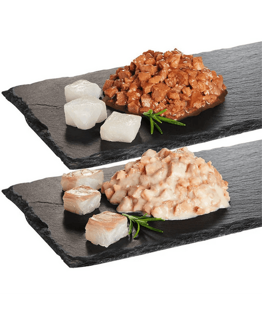 High quality cat food showing moist pieces of pollock and cod served on a dark slate platter.