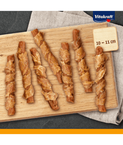 Vitakraft dog training treats, pure chicken twisted around carrot sticks, premium adult dog snacks on a wooden board.
