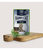 Happy Cat Culinary Farm Lamb in Sauce Wet Cat Food for Sterilised Cats - 85g in a gourmet packaging on a wooden cutting board.