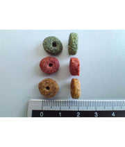 Assorted dry cat food pellets of various colors, representing balanced nutrition cat food, with ruler for size reference.